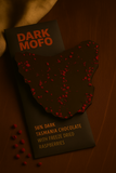 Dark chocolate bar with freeze-dried raspberries and 'Dark Mofo' branding on a wooden surface.
