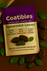 Coatibles Spearmint Leaves chocolate packaging on a brown background with chocolate leaves.