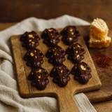Frog shaped Chocolate on a wooden board with honeycomb and flowers on a wooden surface.