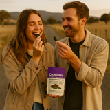 Two people outdoors, one holding a package of 'Coatibles Spearmint Leaves', both smiling.