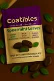 Coatibles Spearmint Leaves chocolate packaging on a brown background with chocolate leaves.
